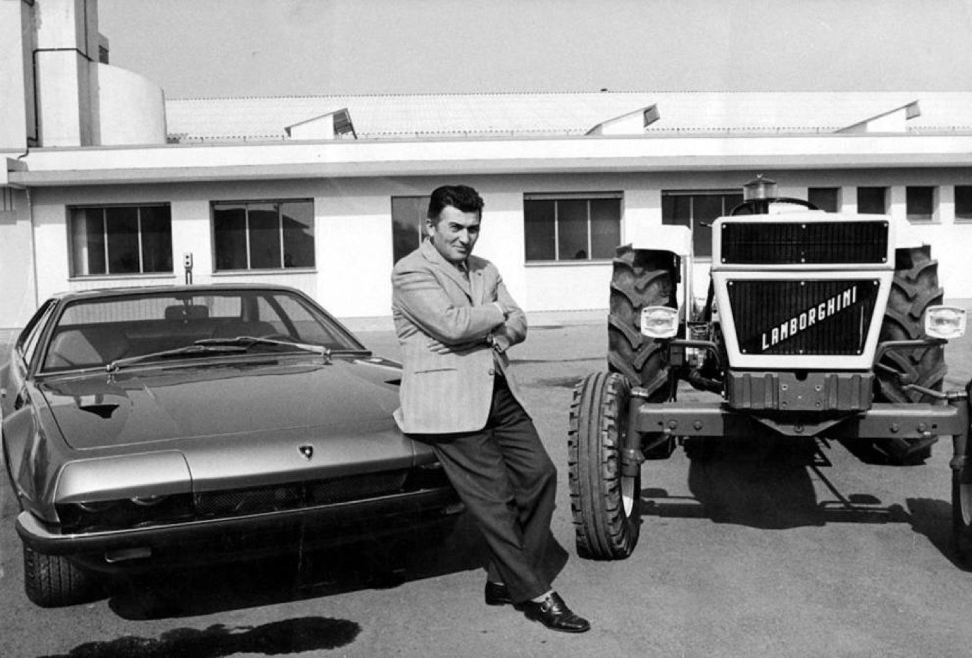 Ferruccio Lamborghini posa entre un deportivo y un tractor de su marca